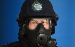 A Queensland police officer in tactical gear poses for a photo during a vehicle search demonstration ahead of the G20 meeting in Brisbane.