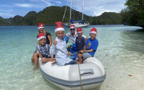 Carolyn and Richard Powles (at the back) with their children: Jackson, Tasman, McKinley and Hawken, all wearing Christmas Santa hats.