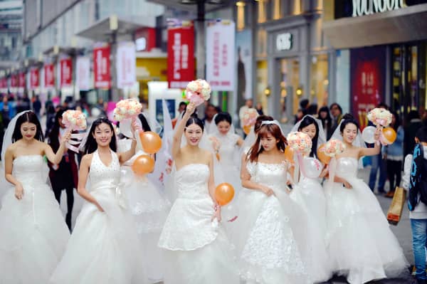 Single women dressed in wedding gowns walk at the Wanda Square before Singles' Day in Chongqing, China, on 9 November, 2014.