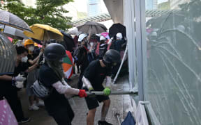 Protesters attempt to break a window at the government headquarters in Hong Kong.