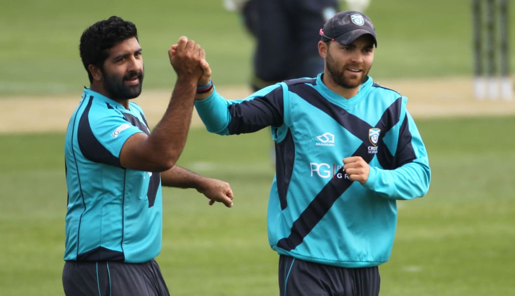 Majid Haq of Scotland celebrates with Preston Mommsen after taking a wicket.