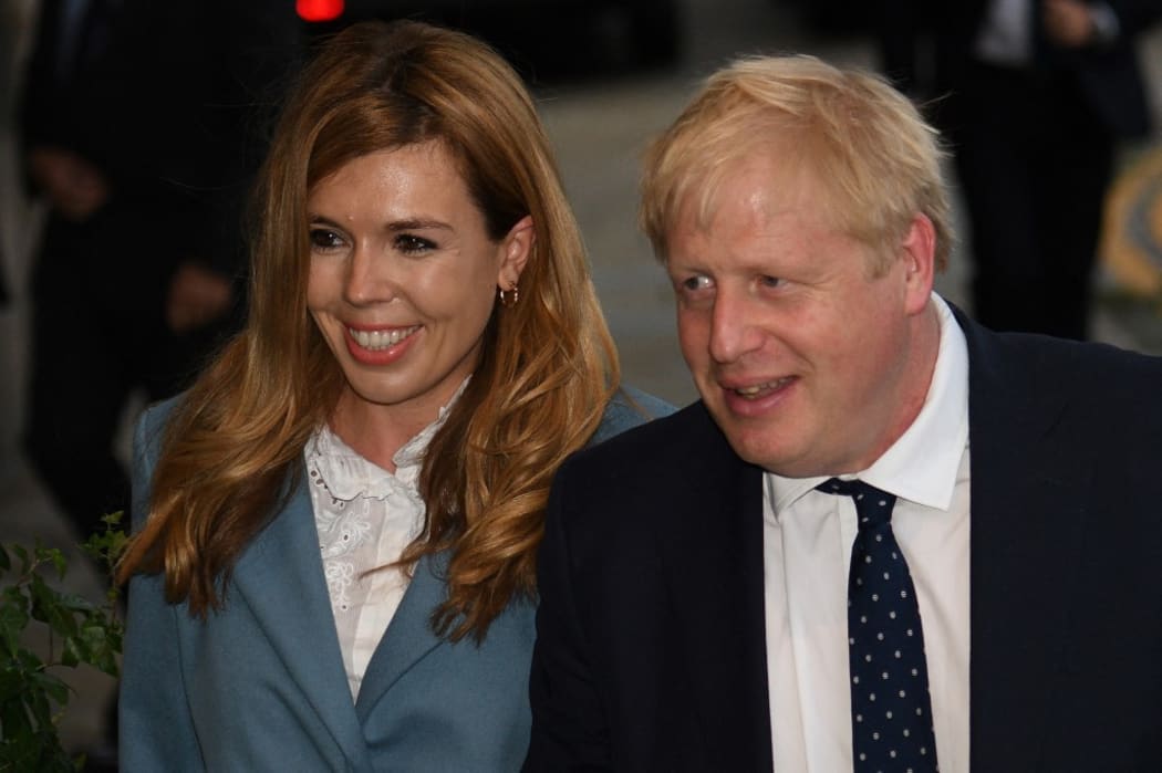 Britain's Prime Minister Boris Johnson walks with his partner Carrie Symonds as they arrive at The Midland, near the Manchester Central convention complex in Manchester, northwest England on September 28, 2019,