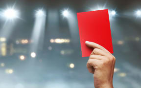 A red card is displayed in a sports stadium.