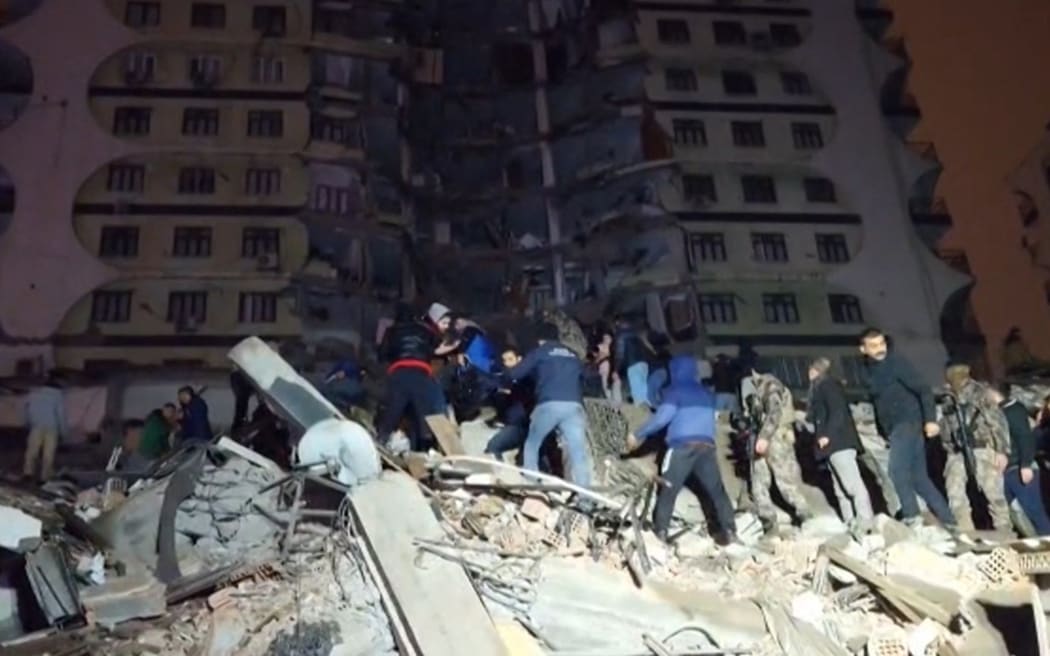 In this video grab from AFP TV taken on February 6, 2023, rescuers search for victims of a 7.8-magnitude earthquake that hit Diyarbakir, in southeastern Turkey, levelling buildings across several cities and causing damages in neighbouring Syria.