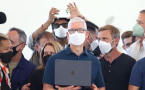Apple chief executive Tim Cook (centre) holds a newly redesigned MacBook Air laptop during the company's annual developer conference, on 6 June, 2022.