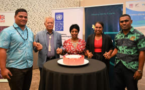 Simon Kofe, Henry Puna and Yemesrach Workie (left to right) join hands with two others for the launch of the Pacific Youth Advisory Board on Governance.