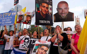 Israelis watch on a screen the release of Edan Alexander, an Israeli-US captive in the Gaza Strip since October 2023, at Hostages Square in Tel Aviv on 12 May, 2025.