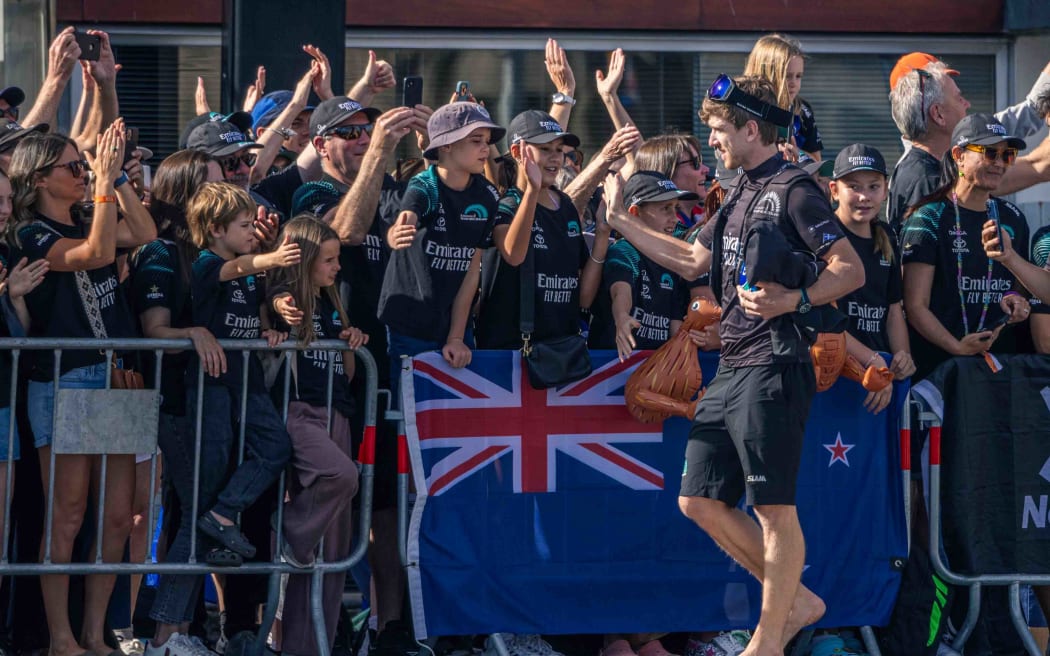 Peter Burling, Team New Zealand skipper, high fives with fans, Barcelona, 2024.