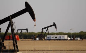 A pump jack and frack tanks in a field being developed for drilling in California.
