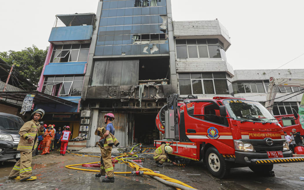 Firefighters are seen at the scene where they have extinguished a fire that killed at least 22 people at a seven-storey building in central Jakarta on 9 December, 2025.