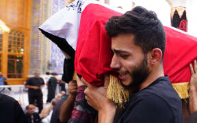 NAJAF, IRAQ - AUGUST 30: People attend funeral ceremony of people killed after Iraq's Shia cleric Muqtada al-Sadr loyalists stormed the Republican Palace in Baghdad, in Najaf, Iraq on August 30, 2022. Karar Essa / Anadolu Agency (Photo by Karar Essa / ANADOLU AGENCY / Anadolu Agency via AFP)