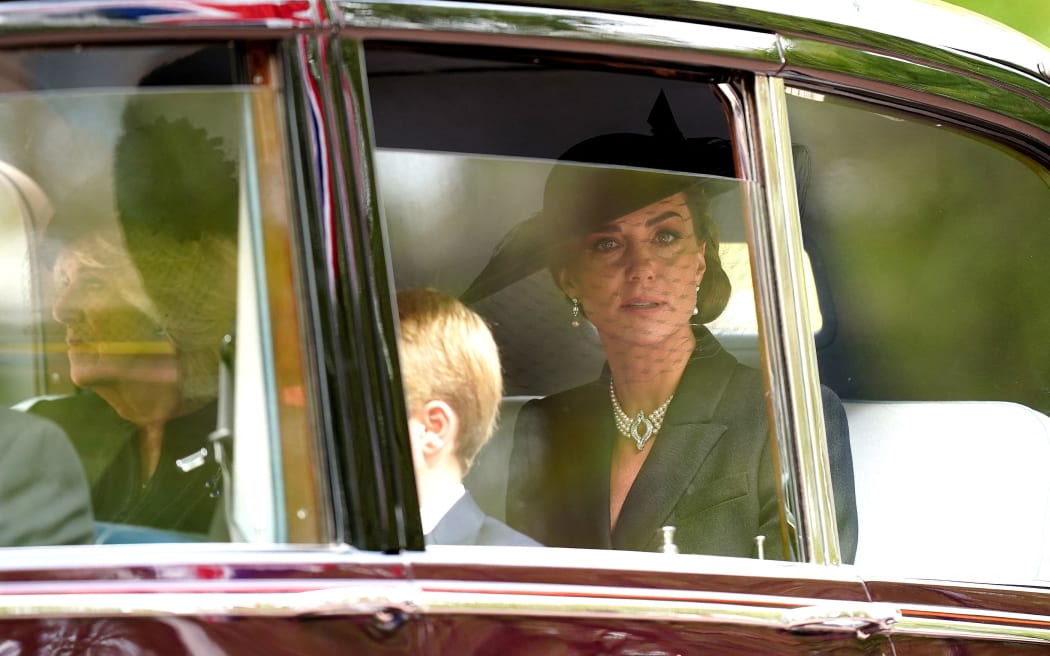 Britain's Catherine, Princess of Wales looks from the window of the car following the coffin of Queen Elizabeth II, as it travels from Westminster Abbey to Wellington Arch in London on September 19, 2022, after the State Funeral Service of Britain's Queen Elizabeth II. (Photo by Mike Egerton / POOL / AFP)