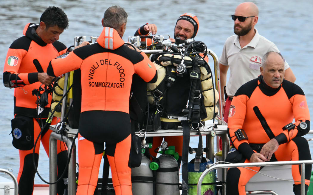 Divers of the Vigili del Fuoco, the Italian Corps. of Firefighters work in Porticello near Palermo, on August 21, 2024 two days after the British-flagged luxury yacht Bayesian sank. Rescuers with divers and an underwater drone search for six people believed trapped when the boat sank. Among the six missing were UK tech entrepreneur Mike Lynch and his 18-year-old daughter Hannah, and Jonathan Bloomer, the chair of Morgan Stanley International, and his wife Judy. The Bayesian, which had 22 people aboard including 10 crew, was anchored some 700 metres from port before dawn when it was struck by a waterspout, a sort of mini tornado. Fifteen people aboard, including a mother with a one-year-old baby, were plucked to safety; one man has been found dead; and six people remain missing. (Photo by Alberto PIZZOLI / AFP)