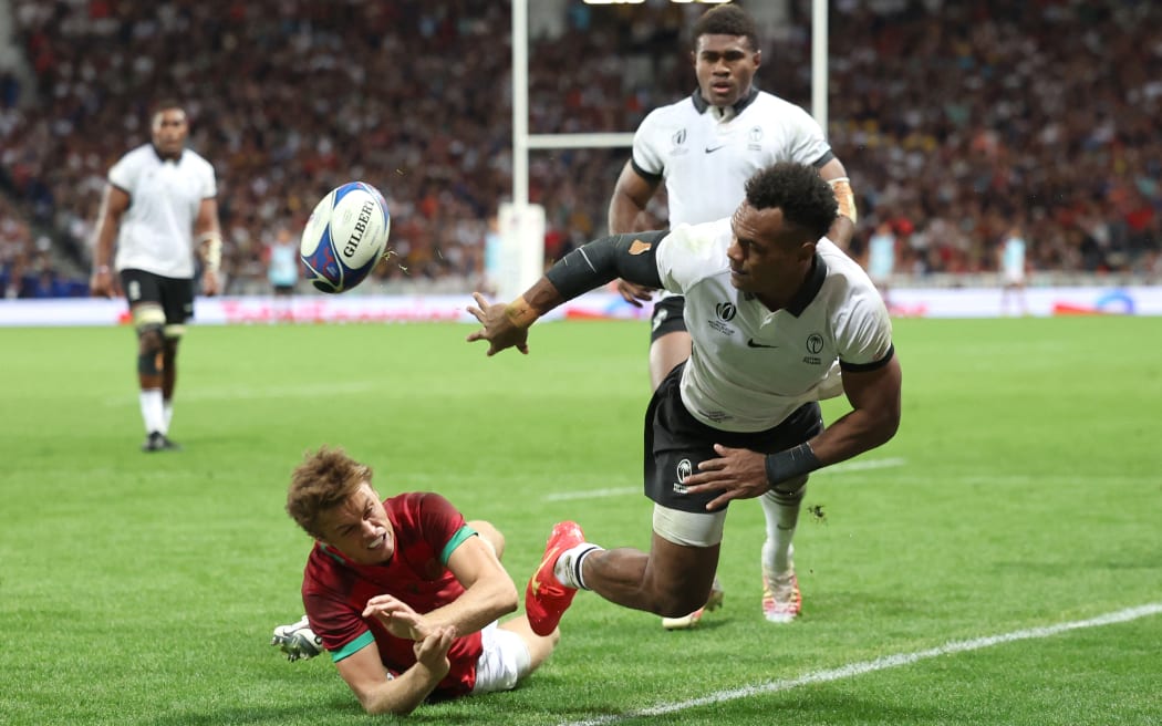 Fiji's full back Sireli Maqala (right) passes the ball ahead of Portugal's fly-half Jeronimo Portela (left) during the France 2023 Rugby World Cup Pool C match between Fiji and Portugal at the Stade de Toulouse in Toulouse, southwestern France on October 8, 2023.