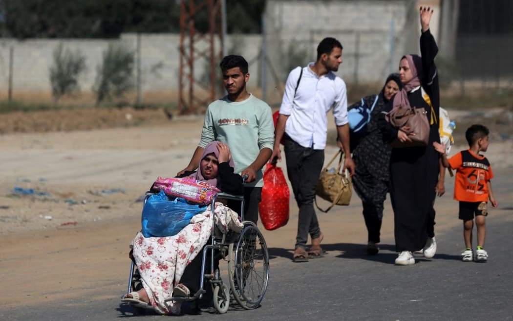 Palestinians walk down a road as they flee Gaza City and other parts of northern Gaza towards the southern areas on November 10, 2023.
