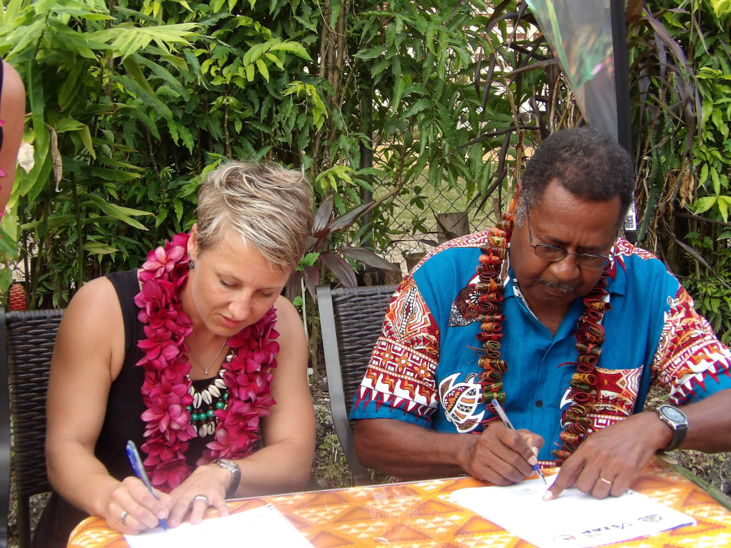 Nicky Barnes signing contract in Vanuatu