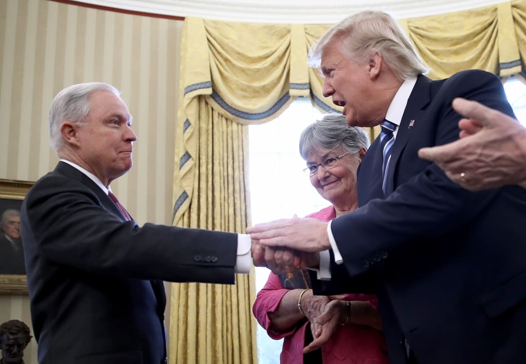 Jeff Sessions shakes hands with US President Donald Trump.