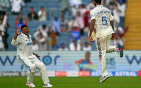 India's Washington Sundar (R) celebrates after taking the wicket of New Zealand's Tim Southee during the first day of the second Test in Pune.