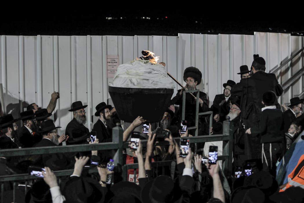 An Ultra-Orthodox Jewish rabbi lights up a bonfire at the grave site of Rabbi Shimon Bar Yochai at Mount Meron in northern Israel on 29 April, 2021, marking the anniversary of the death of the Talmudic sage about 1900 years ago.
