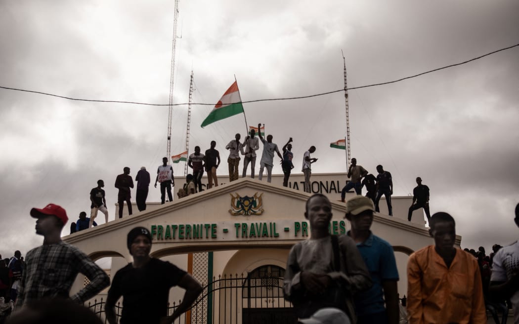 Protesters hold a Niger flag during a demonstration on independence day in Niamey on August 3, 2023. Hundreds of people backing the coup in Niger gathered on August 3, 2023 for a mass rally in the capital Niamey with some brandishing giant Russian flags.
The demonstrators converged at Concertation Square in the heart of the city, following a call by a coalition of civil society associations on a day marking the country's 1960 independence from France. (Photo by AFP)