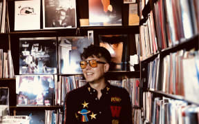 Josh Leys standing wearing glasses in a vinyl shop.