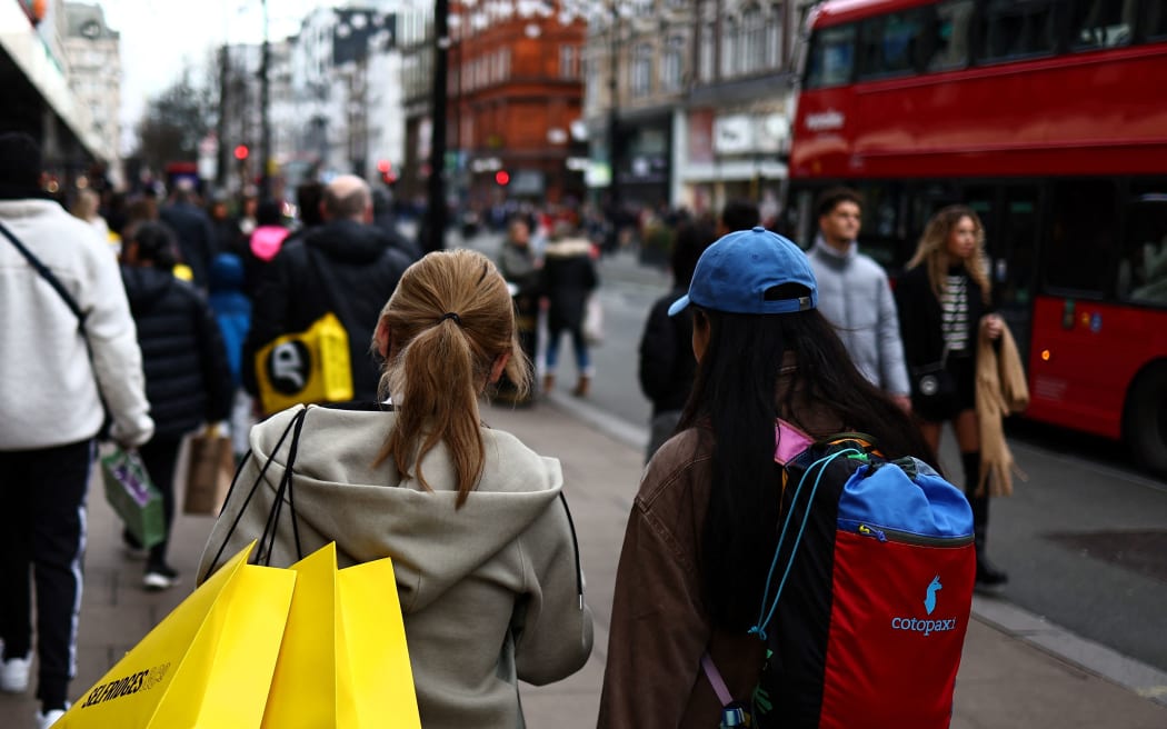 Shoppers carry their shopping bags along Oxford Street during the Boxing Day sales in London on December 26, 2023. (Photo by HENRY NICHOLLS / AFP)