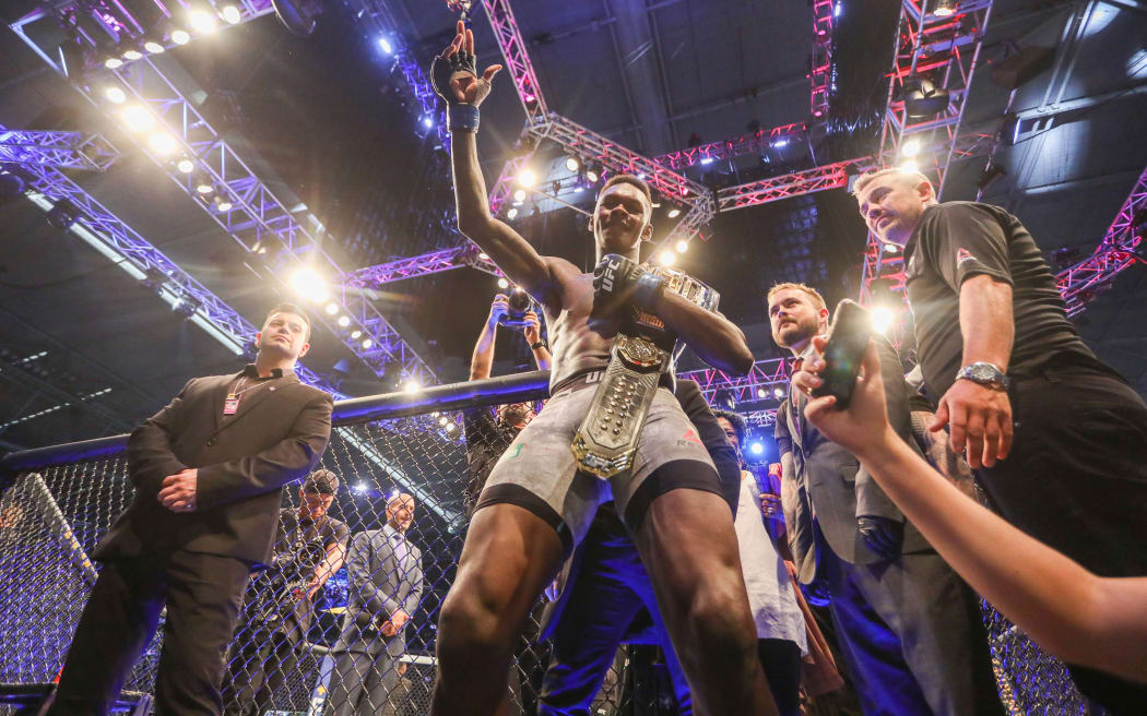 Israel Adesanya celebrates winning the UFC middleweight world title belt.