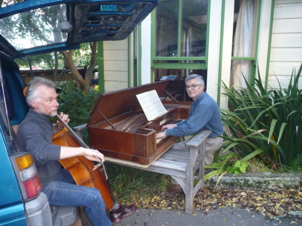 Robert and Douglas taking a break as they remove Douglas' piano through the window of his home.