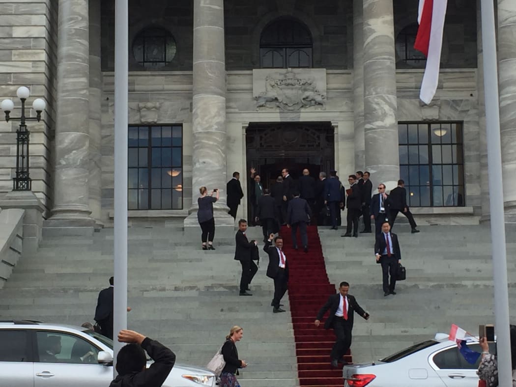 Indonesia's president Joko Widodo disappearing up the steps and into parliament, as his foreign minister Retno Marsudi waves out. 19 March 2018