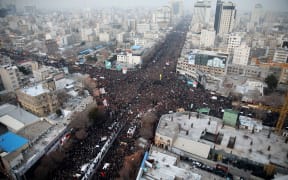 Iranians march behind a vehicle carrying the coffins of slain major general Qassem Soleimani and others as they pay homage in the northeastern city of Mashhad on January 5, 2020.