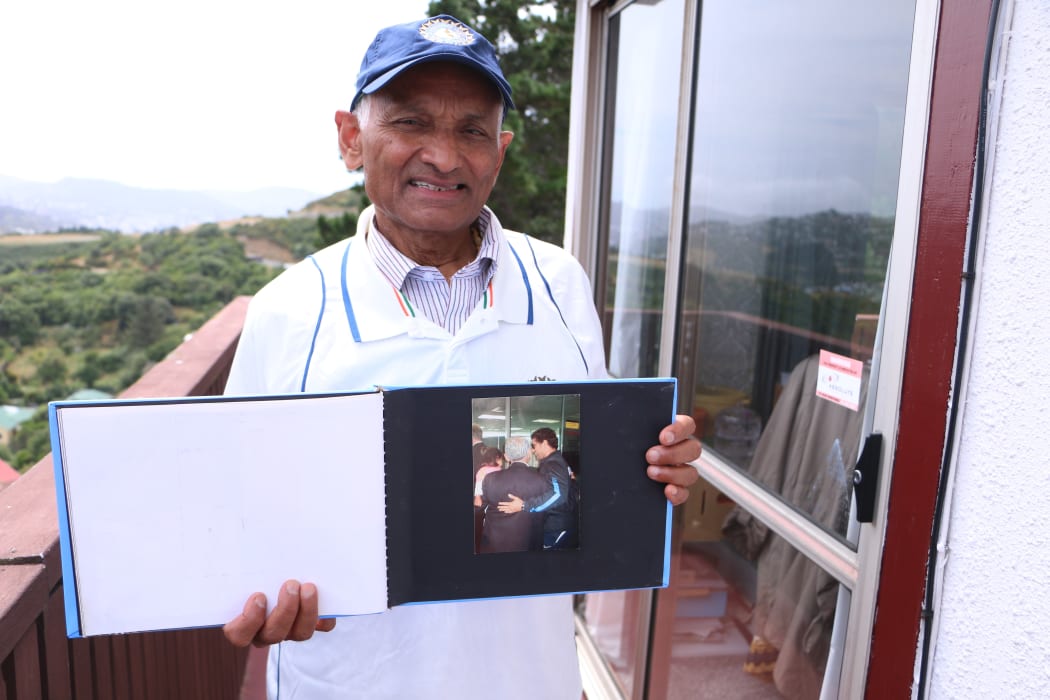 Nanubhai Ranchhod holds his photo album with his prized photo of him and legendary cricketer Sachin Tendulkar hugging at the airport.