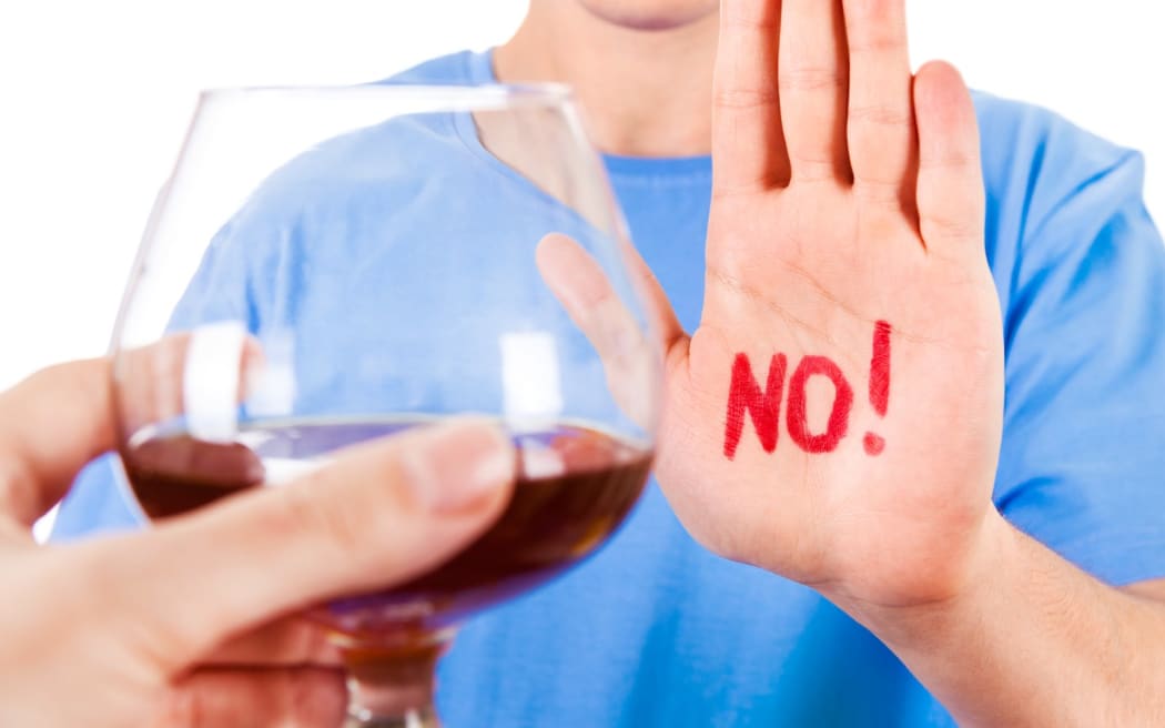 Young Man refuse Glass of Brandy on the White Background