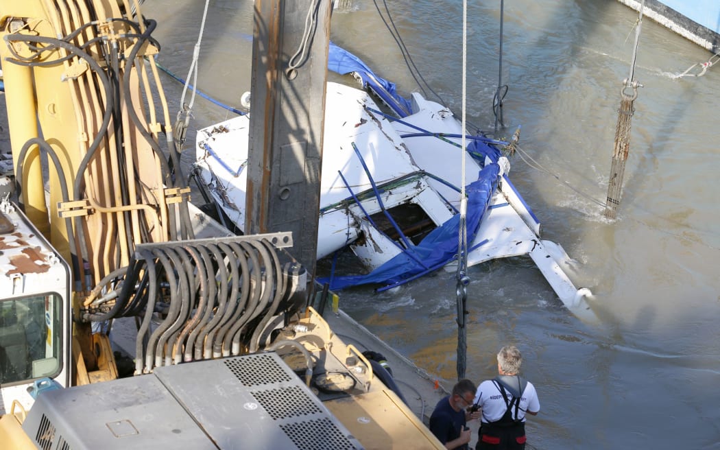 A crane lifts the sightseeing boat out of the Danube river in Budapest, Hungary, Tuesday, June 11, 2019. Eight people are still missing from the May 29 collision between the Hableany (Mermaid) sightseeing boat and the Viking Sigyn river cruise ship at Budapest's Margit Bridge.