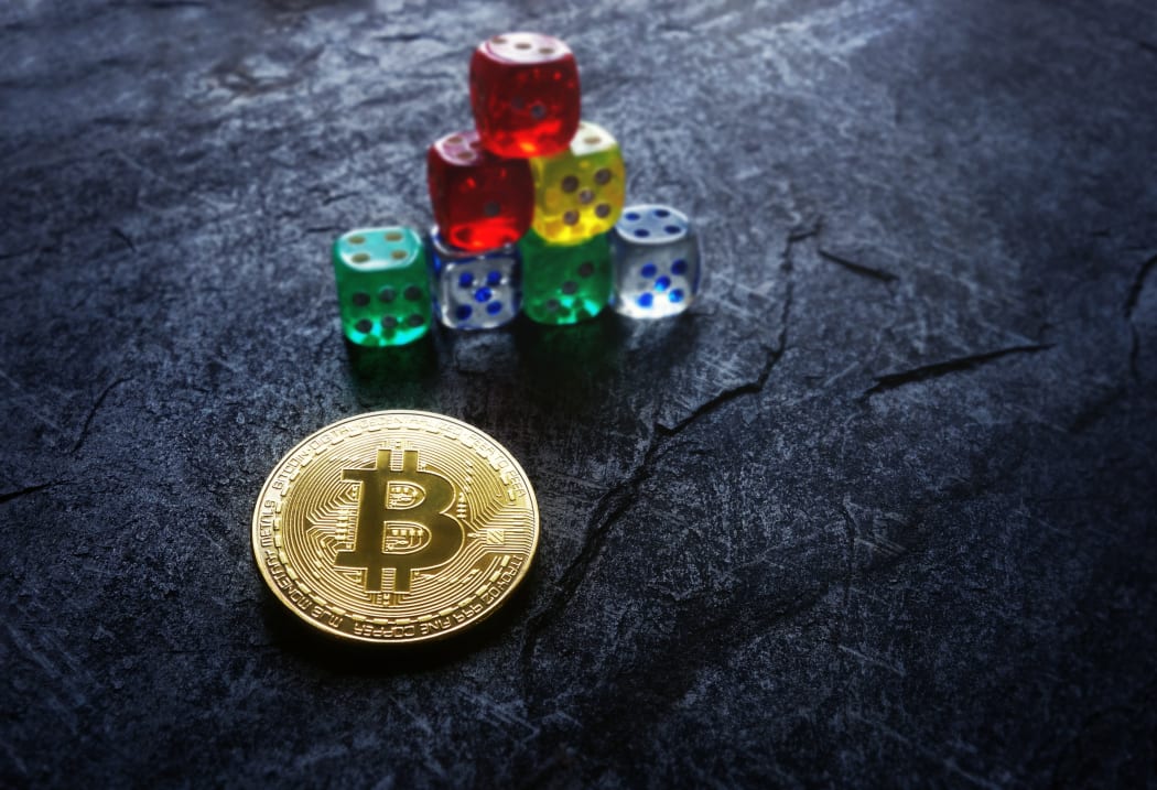 Gold bitcoin and stacked dice -- cryptocurrency investing and risk concept