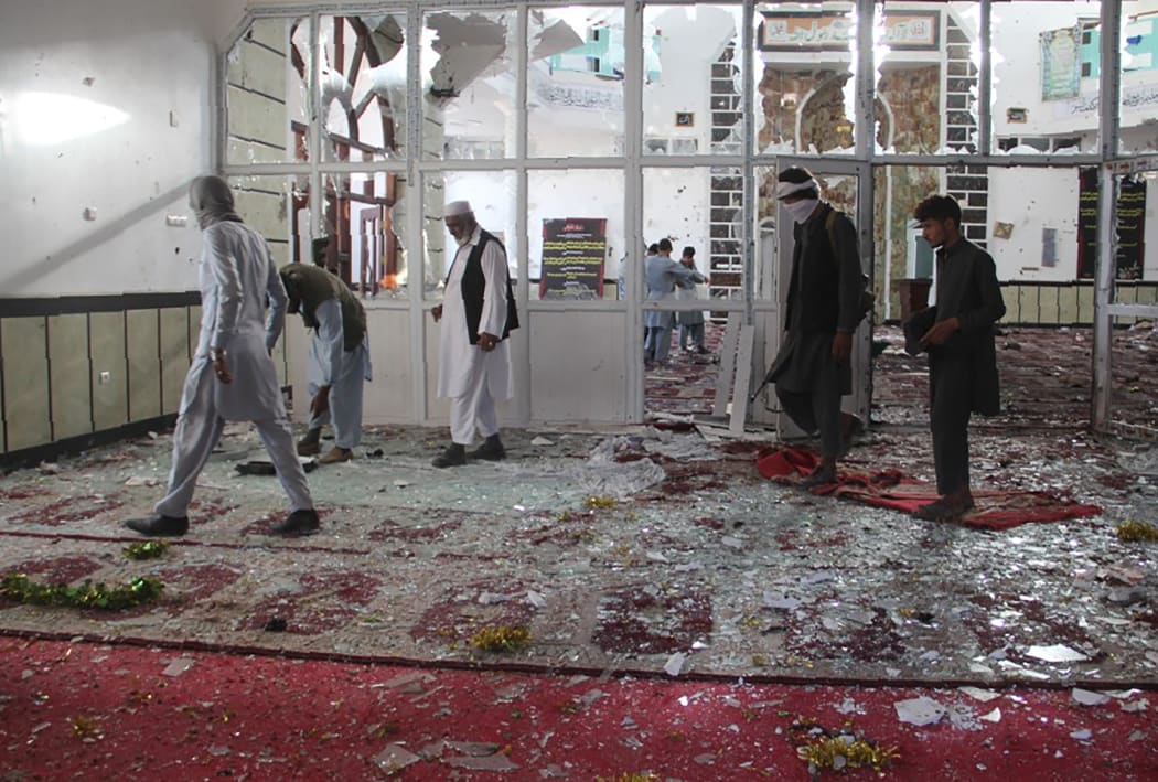 Afghan residents walk inside a damaged mosque after a suicide attack during Friday prayers in Gardez of Paktia province.