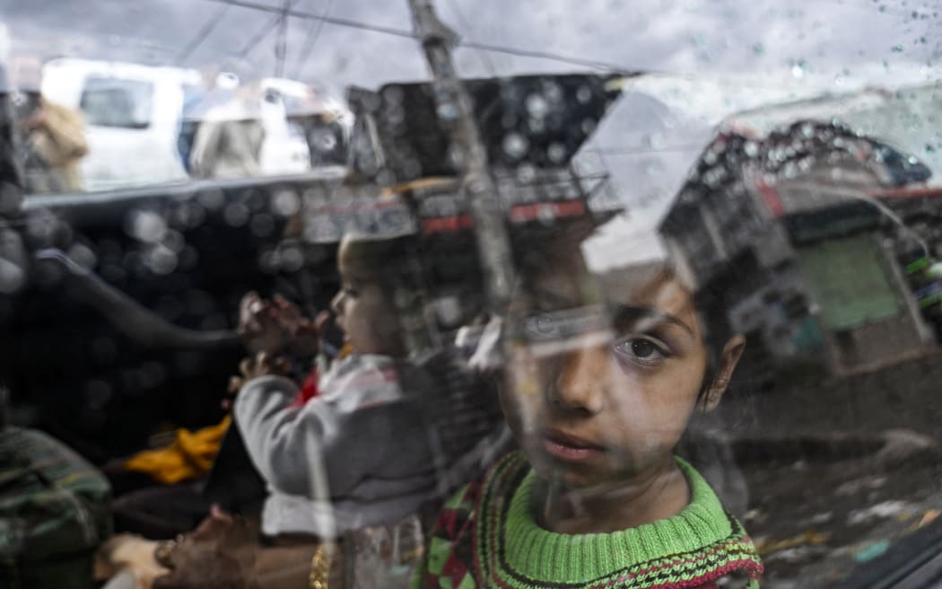 A girl looks out the window of a car as she returns to her hometown after India-Pakistan ceasefire in Uri, about 100kms from Srinagar on May 11, 2025. A ceasefire appeared to hold on May 11, between India and Pakistan, hours after the nuclear-armed rivals accused each other of violating a truce that brought them back from the brink of all-out war. (Photo by Tauseef MUSTAFA / AFP)