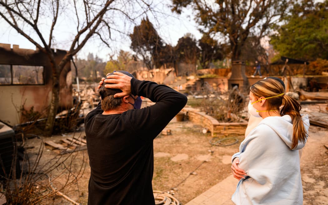 Aaron Lubeley reacts as he arrives at his burned home during the Eaton fire in the Altadena area of Los Angeles county, California on January 9, 2025. Wildfires threatened to engulf parts of Hollywood on January 9 as a growing number of blazes raged across Los Angeles, forcing over 100,000 people to flee their homes and claiming at least five lives. (Photo by JOSH EDELSON / AFP)