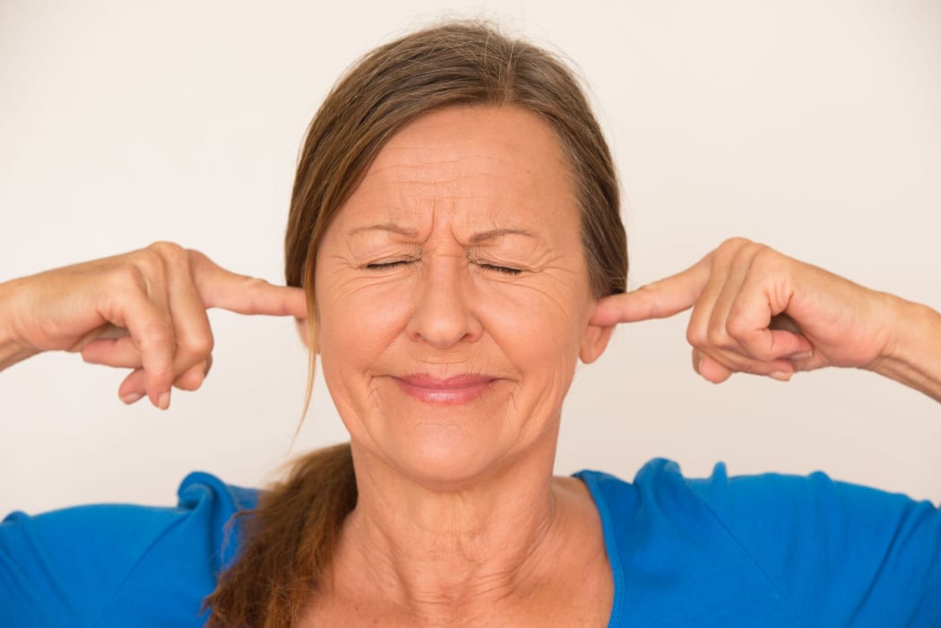 woman blocking her ears