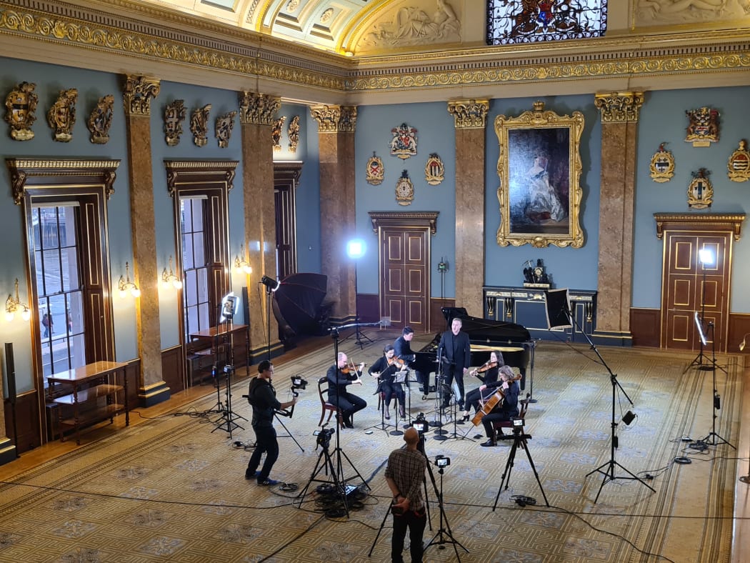 String quartet, grand piano, singer and video crew set up to perform in the beautiful Fish Monger's Hall in London.