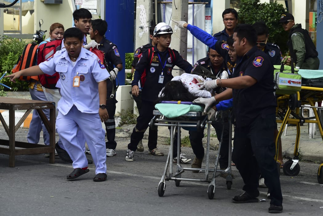 Rescue workers help an injured victim after a string of small bombs exploded in the Thai resort town of Hua Hin.
