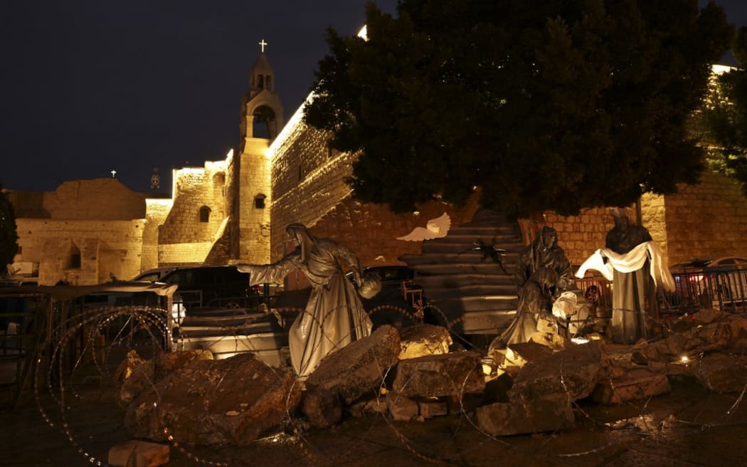 An installation depicting the nativity of Christ with a figure "symbolizing baby Jesus lying in his manger amid rubble", in reference to Gaza, is displayed in front of the Church of the Nativity in the city of Bethlehem in the occupied West Bank on December 23, 2023. (Photo by HAZEM BADER / AFP)