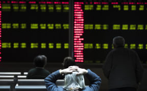 Chinese investors watch stock market movements at a securities company in Beijing.