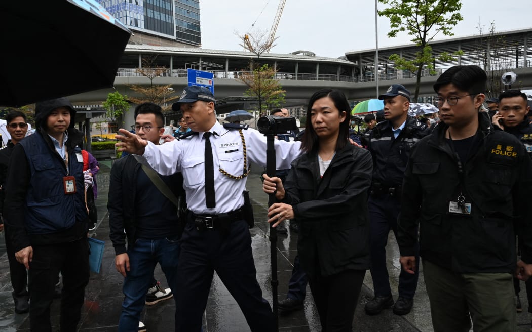 Police watch as a group of residents hold the first authorised protest and march in several years in Hong Kong against the proposal for reclamation in the district on Tseung Kwan O on 26 March, 2023.
