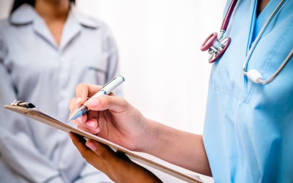 Doctor with clipboard takes patient's notes