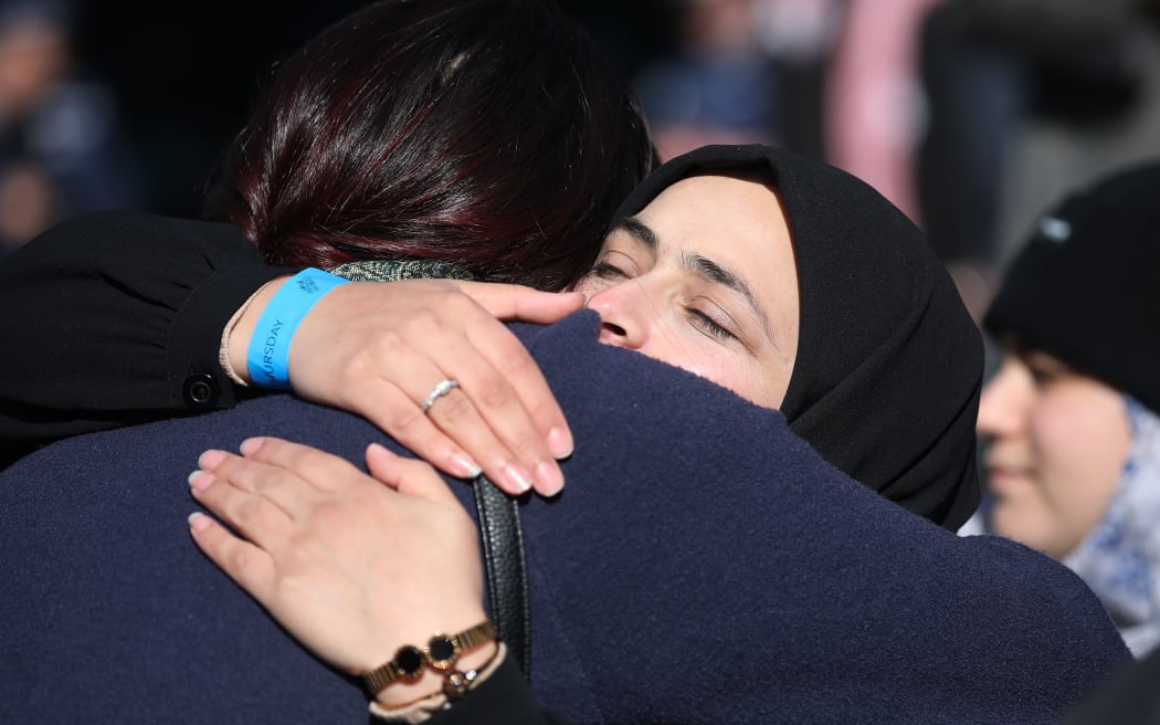 A family member of a victim thanks and celebrates with a member of the public outside the High Court after the judgement and the last day of the sentencing hearing for Australian white supremacist Brenton Tarrant in Christchurch on August 27, 2020. -