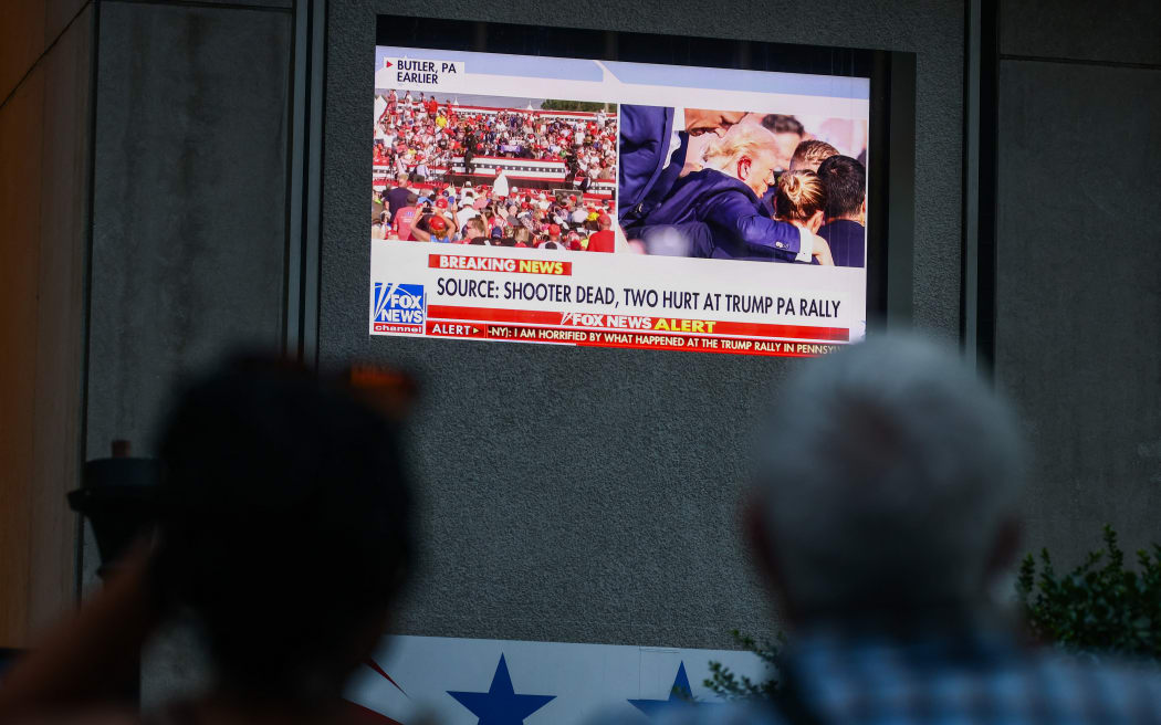 People watch Fox News channel in front of Fox News building in Manhattan after the former U.S. President Donald Trump has been injured during shooting at campaign rally at the Butler Farm Show in Butler, Pennsylvania. New York, United States of America on July 13th, 2024. The suspected shooter was killed and another rally attendee was dead. (Photo by Beata Zawrzel/NurPhoto) (Photo by Beata Zawrzel / NurPhoto / NurPhoto via AFP)