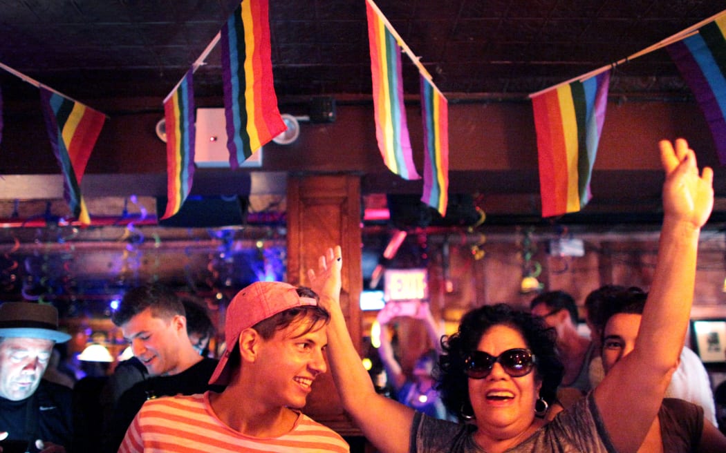 People celebrate inside the Stonewall Inn, an iconic gay bar recently granted historic landmark status in New York's West Village.