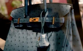 The Bleu Izmir Ostrich Birkin, size 30, is inspired by the coastal city of Izmir in Turkey. It features the iconic Hermes double straps with a turn lock, and a Hermes engraved zipper pull.