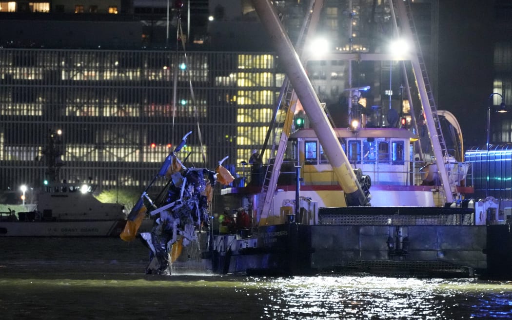 The wreckage of a helicopter is removed from the water after crashing into the Hudson River, in the Newport neighborhood of Jersey City, New Jersey, on April 10, 2025. Six people including three children were killed after a sightseeing helicopter crashed into the Hudson River in New York on Thursday, sparking a major water rescue operation, authorities said. The crash killed all those onboard the aircraft: the pilot and a family from Spain. Two of the victims were initially taken to a hospital, but later succumbed to their injuries. (Photo by Leonardo Munoz / AFP)