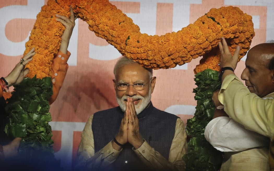 Indian Prime Minister Narendra Modi receives a giant floral garland from party leaders at their headquarters in New Delhi, India.
